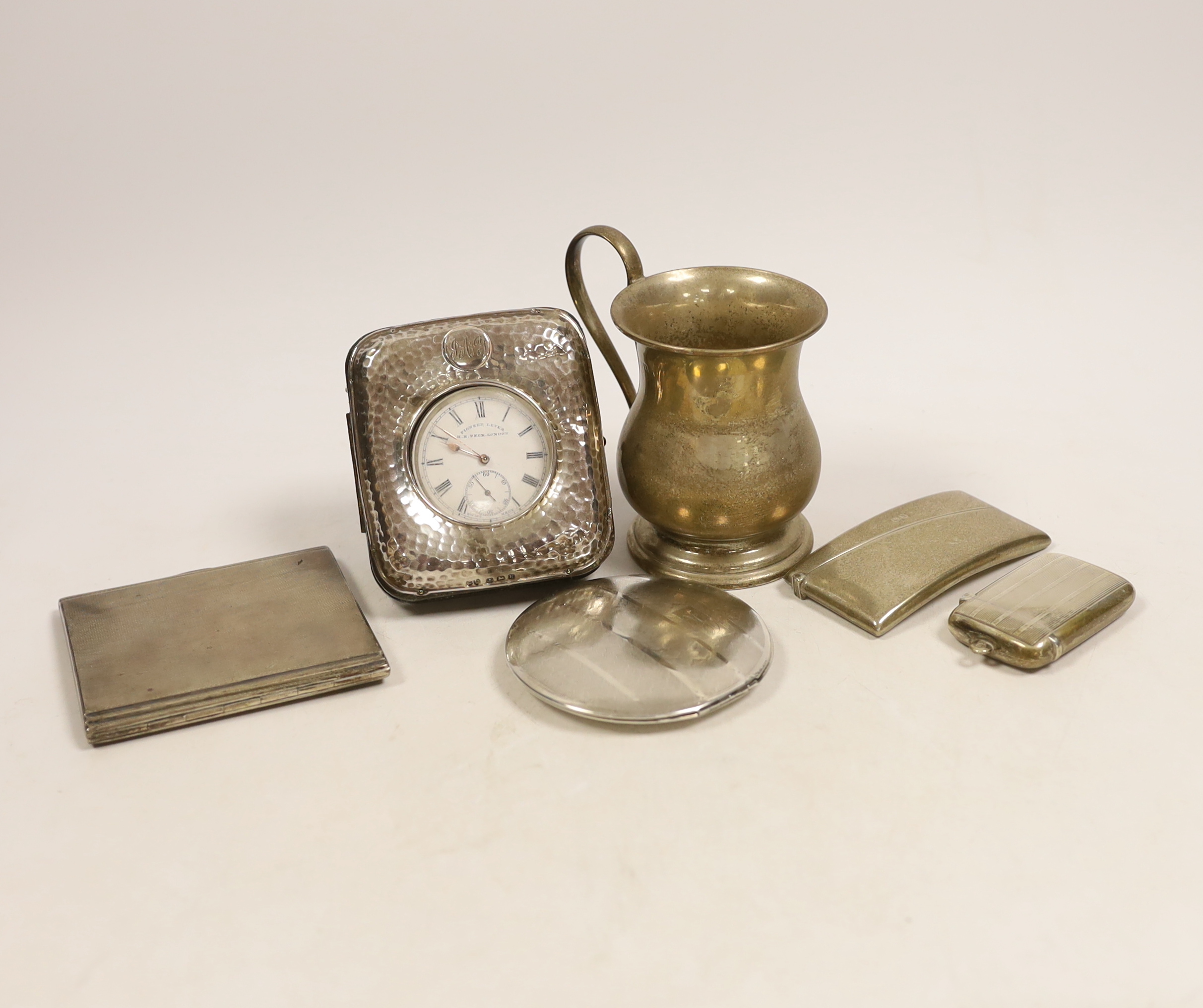 A George V silver baluster christening mug, height 9.7cm, an Edwardian silver mounted travelling watch case, containing a silver pocket watch by Peck of London, a silver card case, silver cigarette case, silver vesta cas